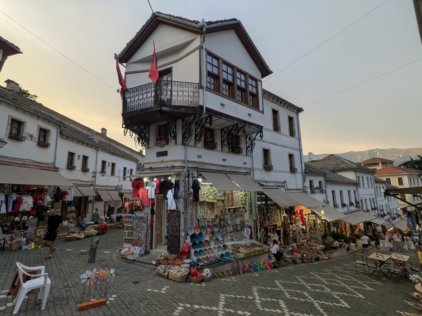Casa otomana con balcón y banderas albanesas en la esquina donde se unen las dos calles del bazar de Gjirokastra