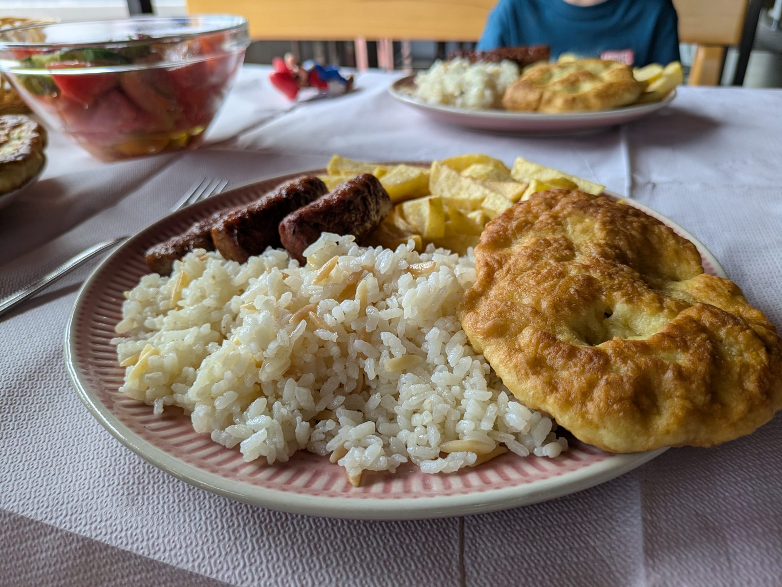 Plato combinado albanés con carne a la parrilla, arroz, patatas y pan frito