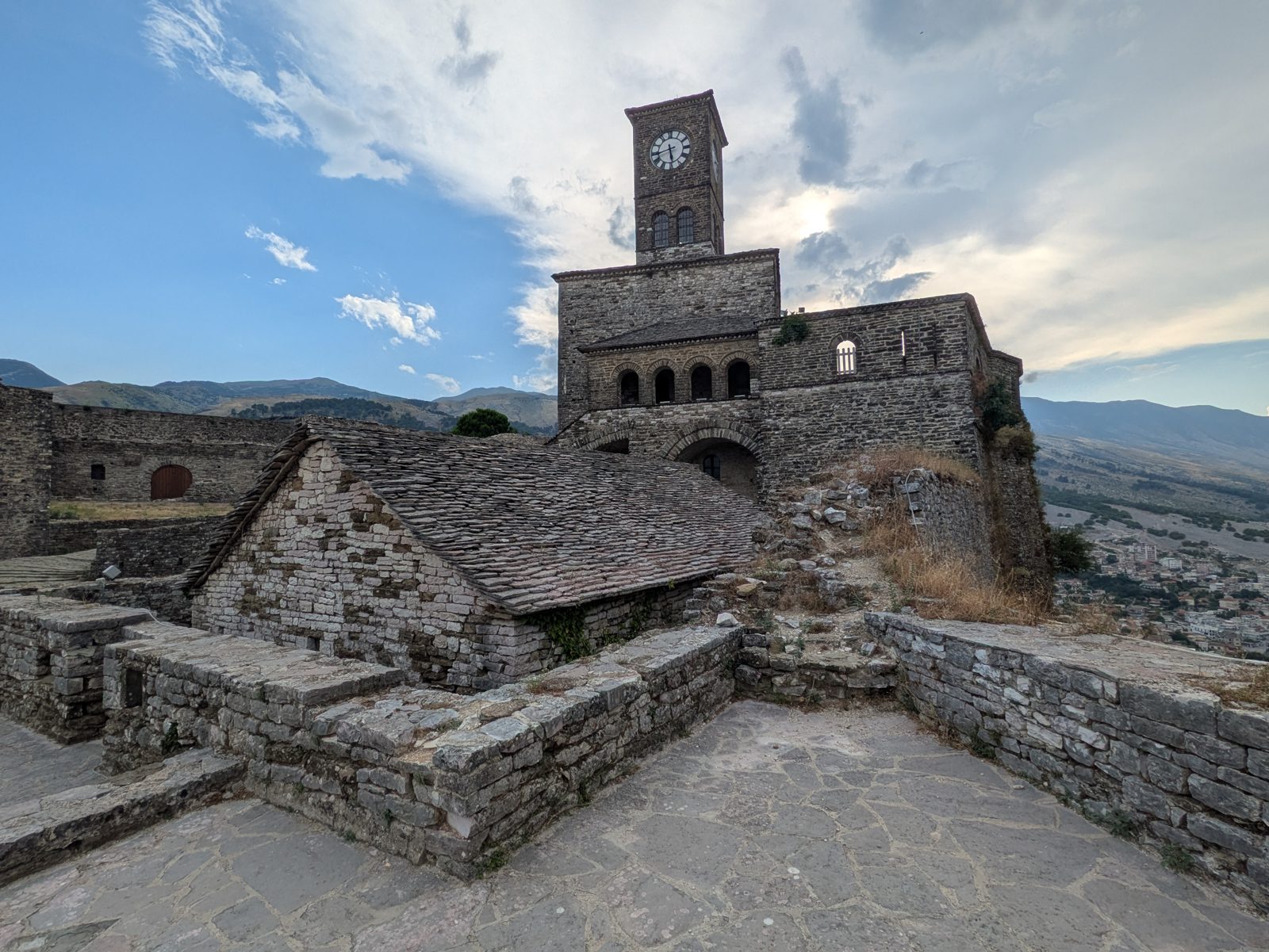 Torre del reloj del castillo de Gjirokastra sobre los tejados de piedra