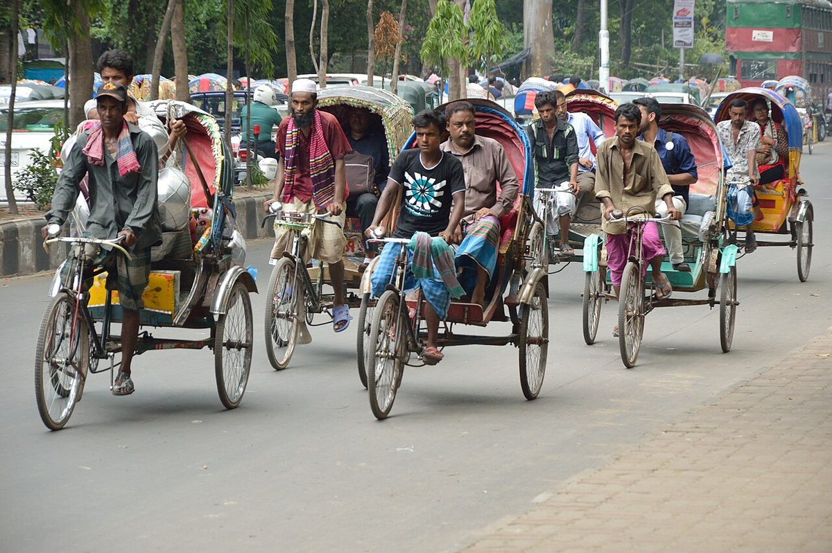 Bicitaxis circulando por una calle de Daca, en Bangladés