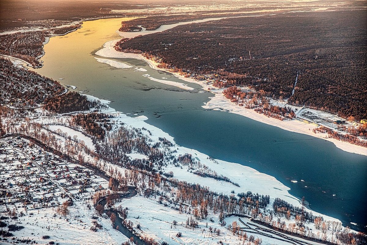El río Obi parcialmente helado al atardecer, en Siberia