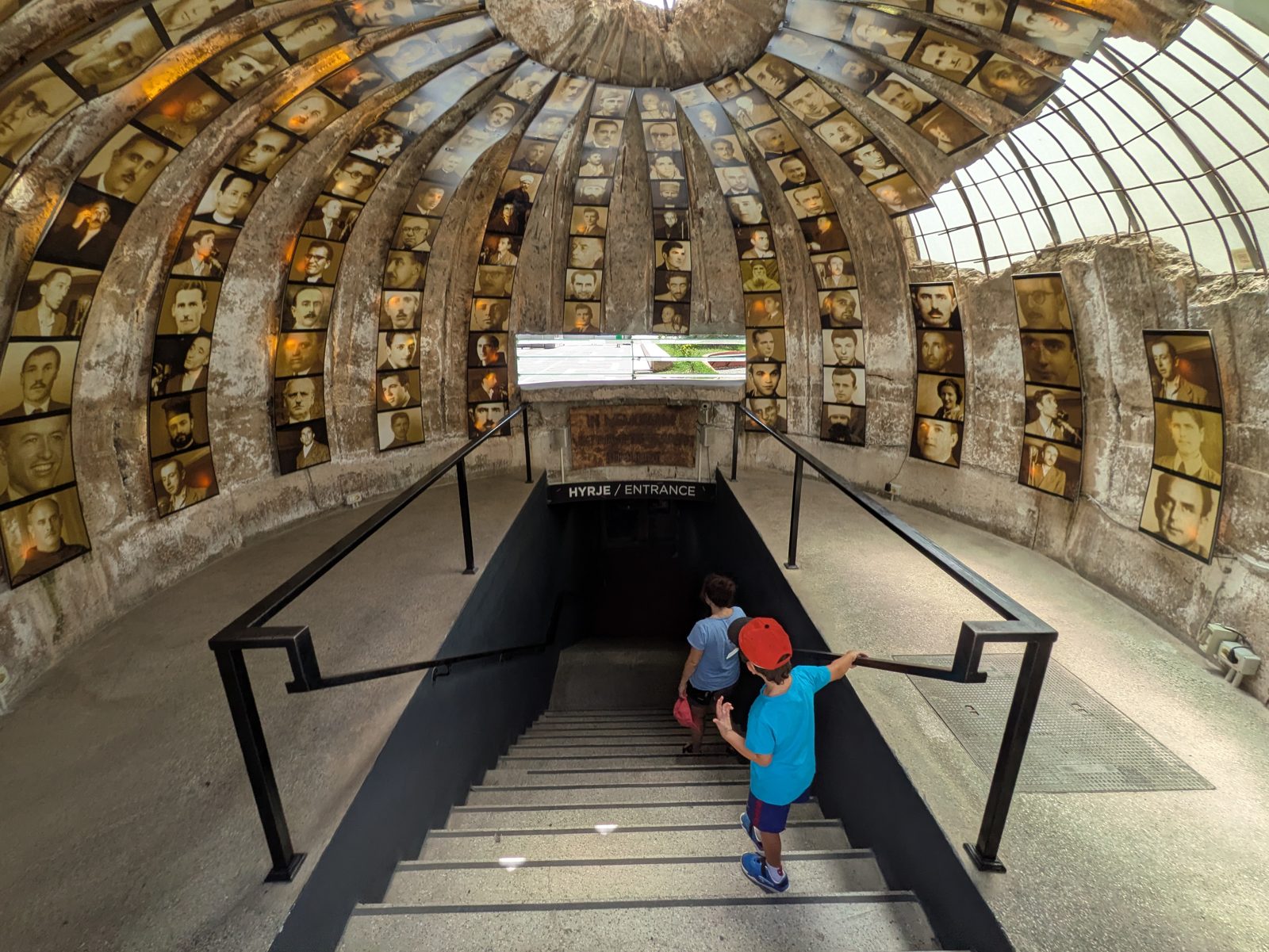 Escalera de bajada al Bunk'Art 2 bajo una cúpula forrada de fotografías