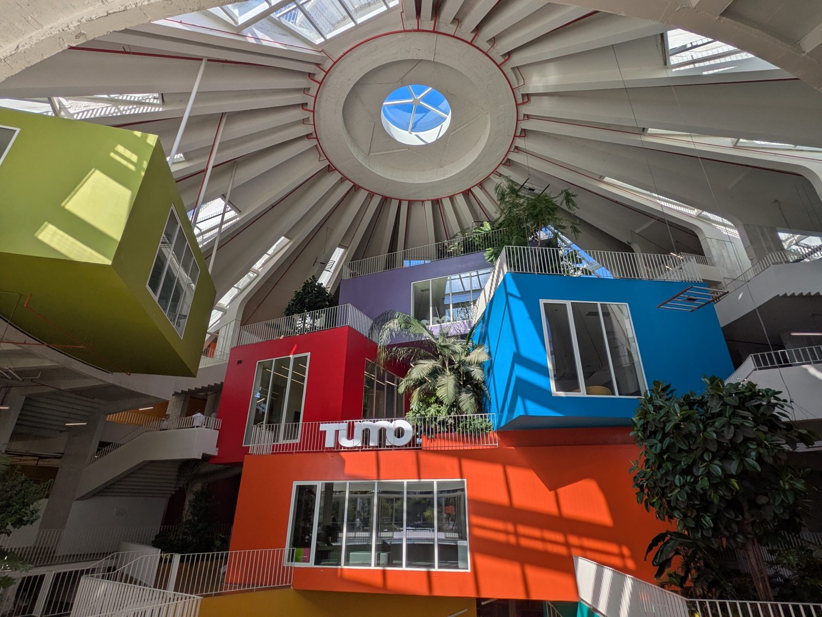 Interior de la Pirámide de Tirana con módulos de colores apilados bajo la cubierta