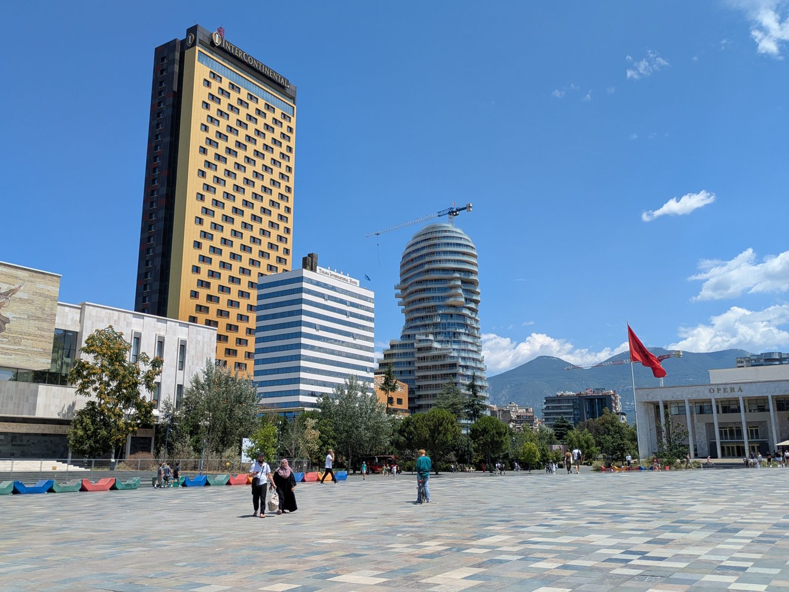 Plaza Skanderbeg de Tirana con los rascacielos del centro y la bandera albanesa